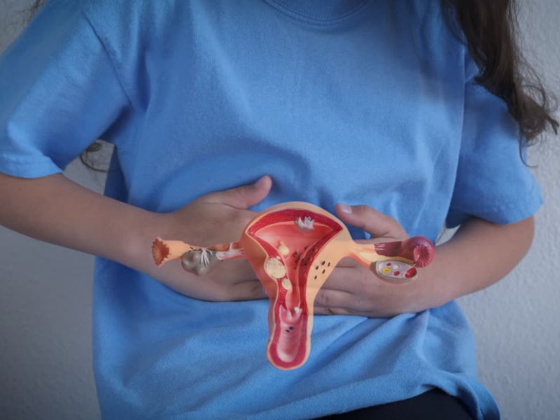 devojka se drži za stomak od bola, prikaz mioma na materici