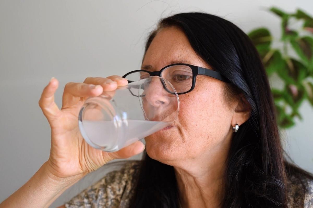 žena srednjih godina pije magnezijum na rastvaranje iz staklene čaše